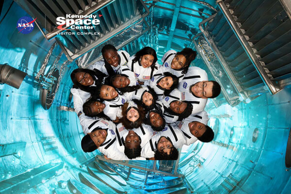 TRIO students dressed like astronauts pose in simulated shuttle at the Kennedy Space Center.