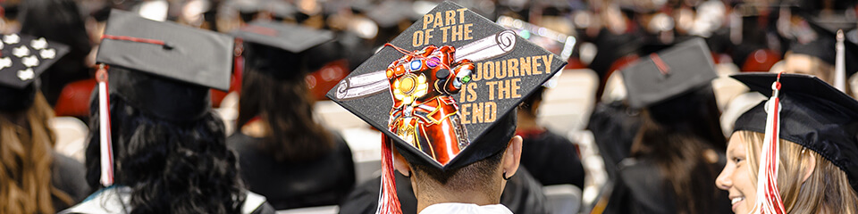 Illinois State graduate with graduation cap that reads 'Part of the Journey is the End'.