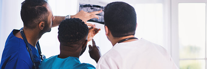 Three people looking at medical imaging.